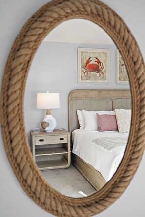 A bedroom with a bed, a nightstand, a lamp, and a wall-mounted mirror. - 4BR Beach House Sleeps 12/Screened Porch/Parking for 6 cars /Rehoboth (Rehoboth Beach)