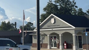 A Welcome Inn sign with an American flag, a Salvation Army building in the background, and a clear sky. - Newly remodeled 14-room hotel in charming St. Mary's . (St. Marys)