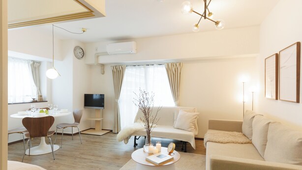 A modern living room with a sofa, coffee table, and dining area. - Baggage OK！Clean, Comfy bed Stay- Dotombori Haven (大阪市中央区島之内2丁目)