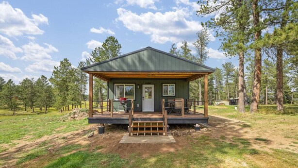 A cabin with a porch, a door, and a window. - Custer Love Shack Getaway (Custer)