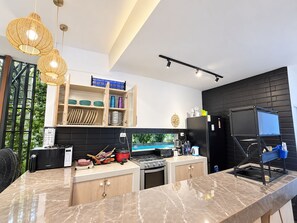 A modern kitchen with a marble countertop, a built-in stove, and a black refrigerator. - Casa 4 habs con aire, piscina y mar a 50 pasos (Zorritos District)