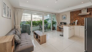 Un appartement moderne comprenant un salon, une cuisine et un balcon.