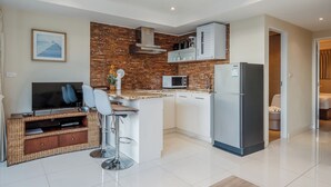 Une cuisine moderne équipée d’un téléviseur, d’un four à micro-ondes et d’un réfrigérateur.