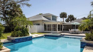 Ein Wohnhaus mit Swimmingpool, überdachter Terrasse und einem eingezäunten Garten.