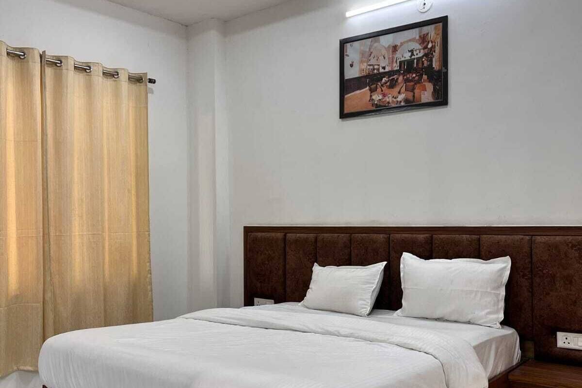 Ein Schlafzimmer mit einem hölzernen Bett, wei ßer Bettwäsche, einem Deckenventilator, einem Bild an der Wand und einem Fenster mit Vorhängen.