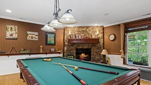 A pool table with balls and cues, a fireplace, a clock, and a window with a view. - unique 1-bedroom apt  Organic Farm&Resort in Murphy with AC (Murphy)