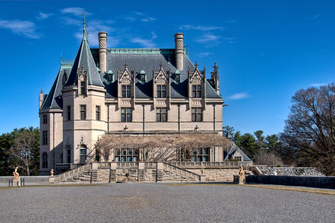 A large, historic building with a prominent tower, a grand entrance with steps, and a symmetrical facade.