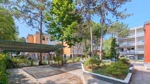 A courtyard with stone paving, a covered seating area, and a poolside lounge.