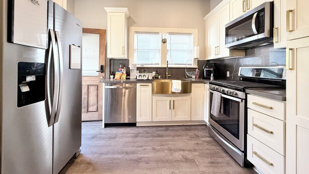 A modern kitchen with stainless steel appliances, a built-in oven, and a microwave. - Light filled apt in Historic Home by UW & Downtown (Seattle)