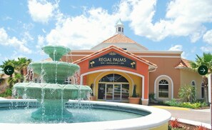 Un edificio con un letrero que dice 'Regal Palms Bar, Restaurant, Spa' y una fuente en el frente.