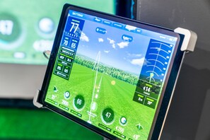 A tablet displaying a golf game interface with various statistics and a virtual golf course.