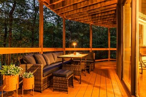 Une terrasse extérieure en bois, avec un canapé, des chaises et une table.