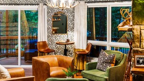 A cozy living room with leather sofas, a green armchair, and a fireplace.