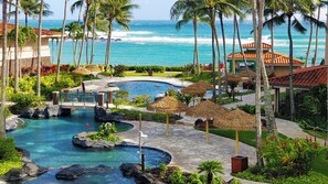 Ein Resort mit Poolbereich, Palmen und Meerblick.