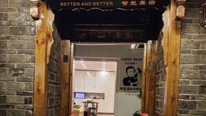Entrada d'hotel amb un rètol que diu "Better and Better" i "Come here".