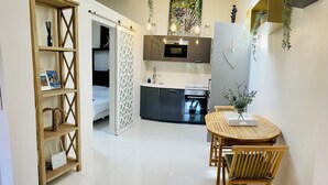 Una cocina moderna con comedor, piso de baldosas blancas y una silla de madera.