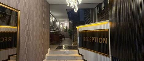 A modern reception area with a marble staircase leading to a second floor.