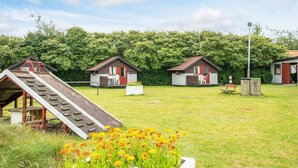 En campingplads med flere hytter, et picnicbord og en legeplads.