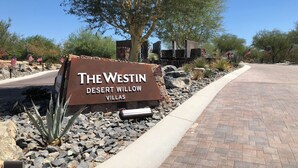 A sign for The Westin Desert Willow Villas with a paved pathway and desert landscaping.