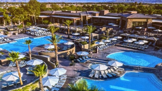 A resort with multiple swimming pools, sun loungers, and umbrellas.