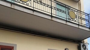 Un edificio con un balcone, una porta e un condizionatore d'aria.