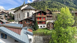 A mountain village with traditional wooden houses, a church, and a mountain backdrop. - Apartment Dala by Interhome (Leukerbad)