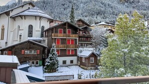 A snow-covered village with traditional wooden buildings, including a church and a hotel with balconies. - Apartment Dala by Interhome (Leukerbad)