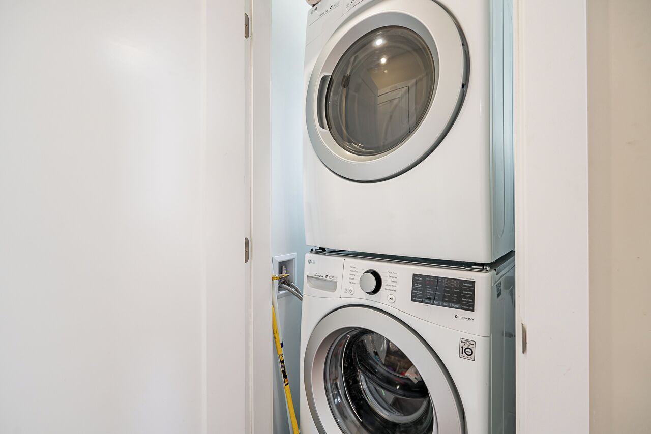 Una lavadora y secadora apiladas en un cuarto de lavado.