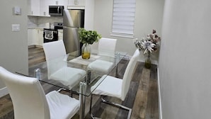 A modern kitchen with white cabinets, a microwave, and a refrigerator. - 3-bedroom townhome in enchanting Abbotsford with AC (Abbotsford)