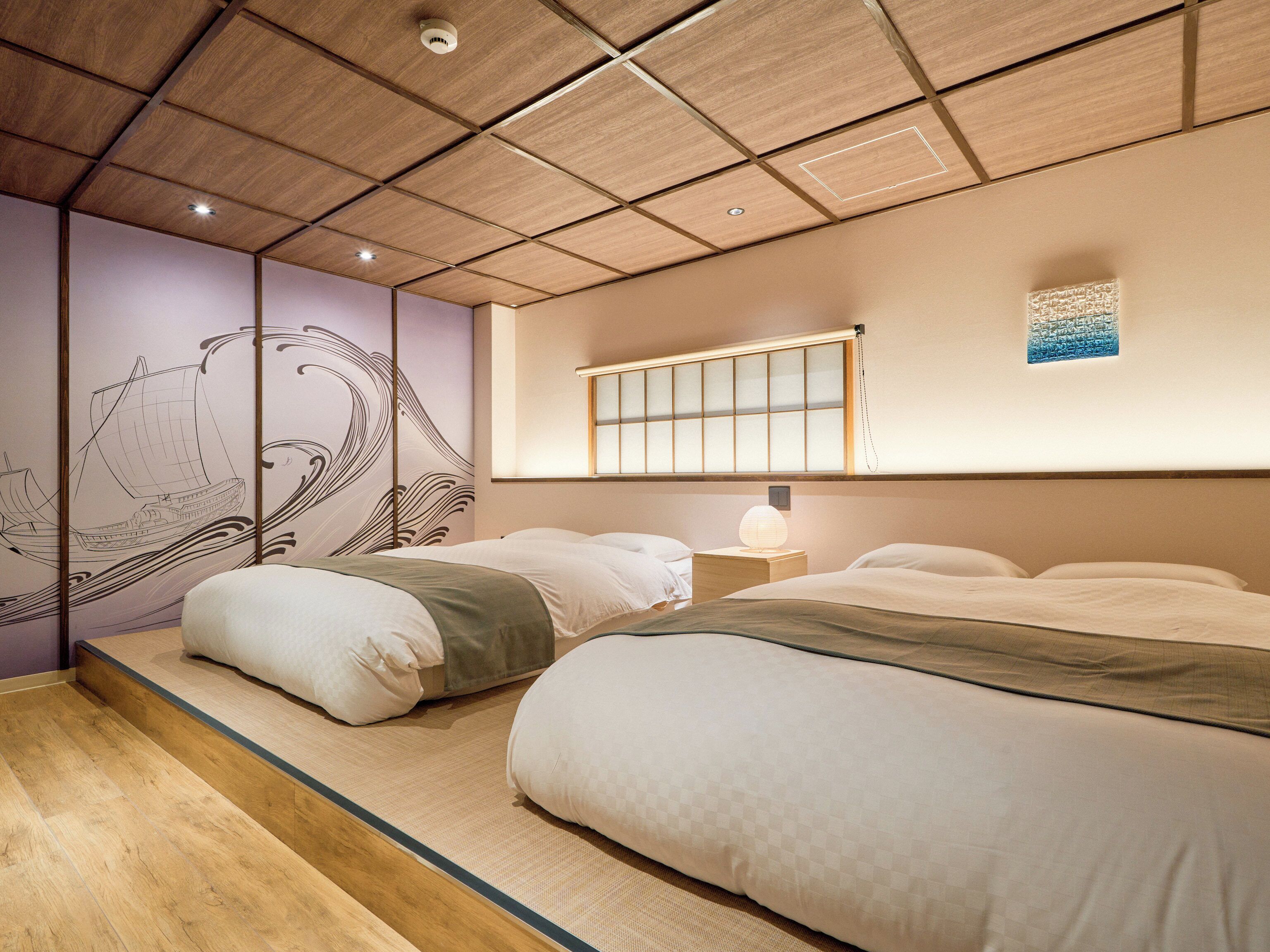 A traditional Japanese-style bedroom with tatami flooring, a shoji screen, and a futon bed.
