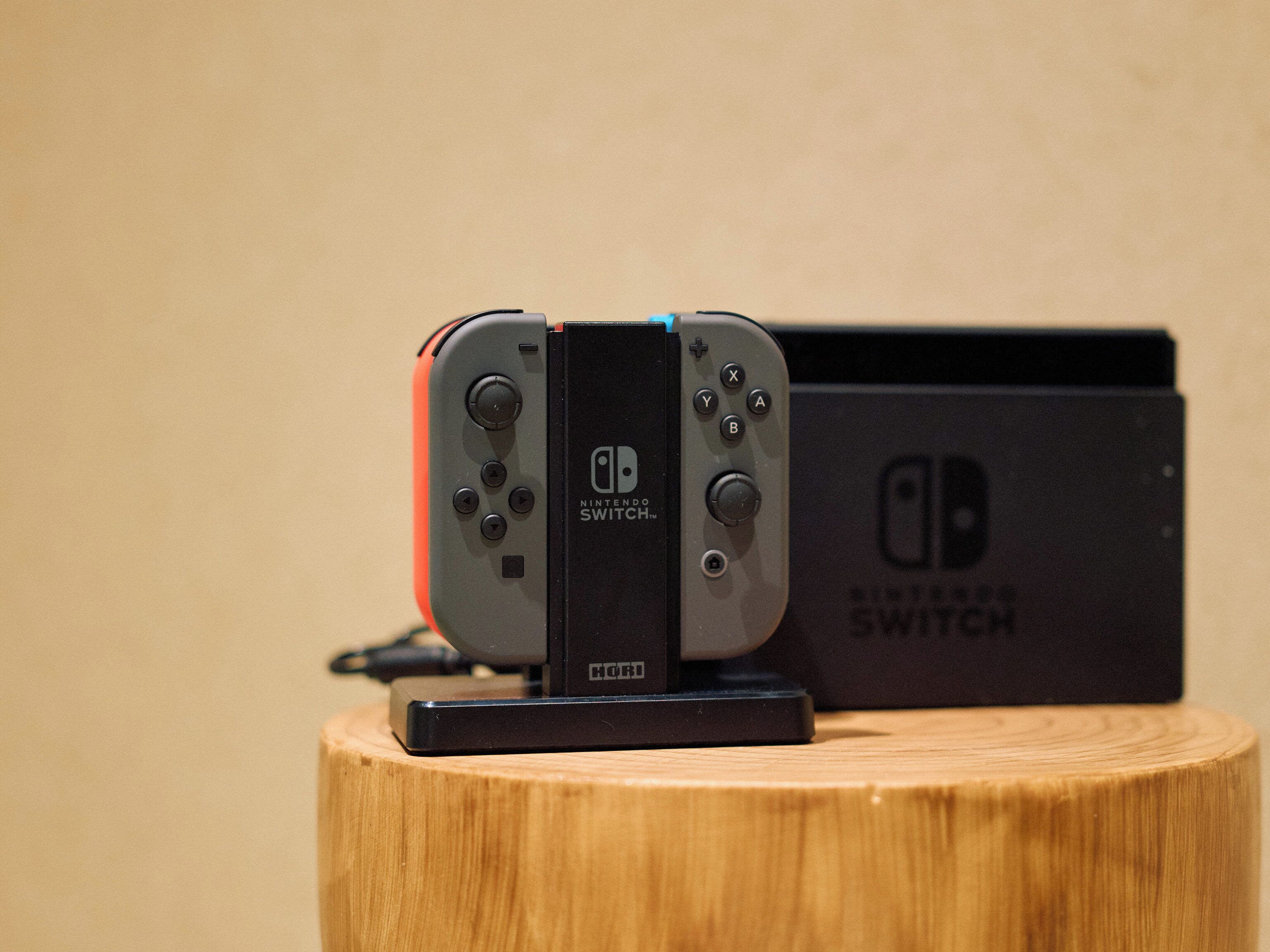 Una consola Nintendo Switch y su caja sobre una superficie de madera.