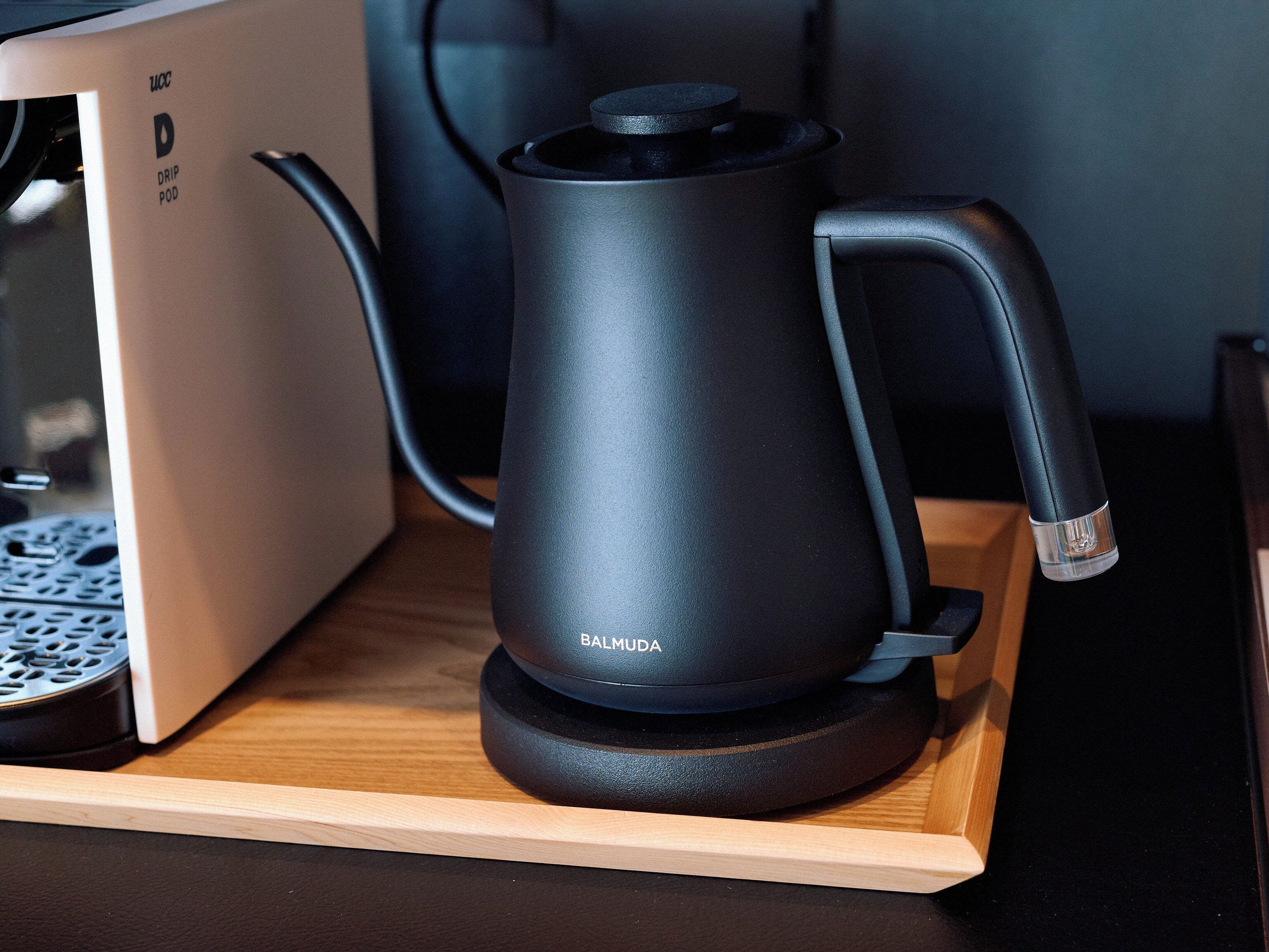 Ein Spender für Kaffeepads mit Tropffilter auf einer Holztablett.