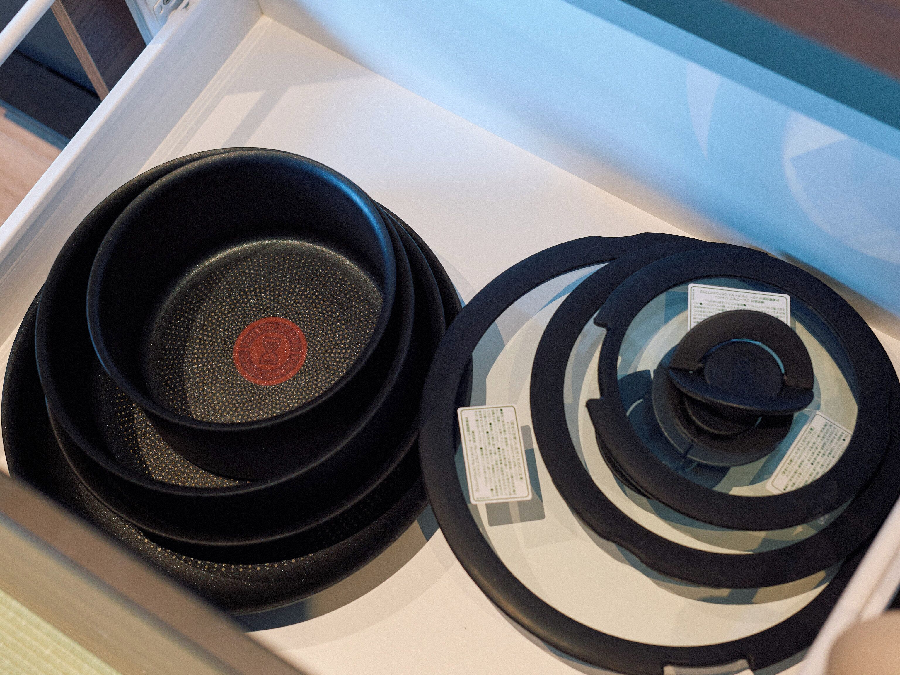 A kitchen with a white countertop and a black pan on it.