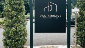 A sign for Oak Terrace with a mountain view.