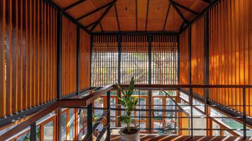 A modern interior with a wooden ceiling, a staircase, and a potted plant.