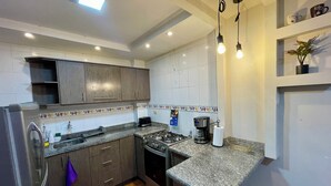 Una cocina moderna con encimeras de granito, electrodomésticos de acero inoxidable y una estufa a gas.