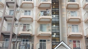 A multi-story residential building with balconies, a central staircase, and a covered entrance. - Cozy City Stay in Baguio (Baguio)