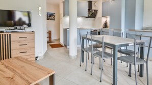 A modern kitchen with a dining area, a TV, and a wooden table. - Central Morzine apartment, 6 pers, south balcony (Morzine)