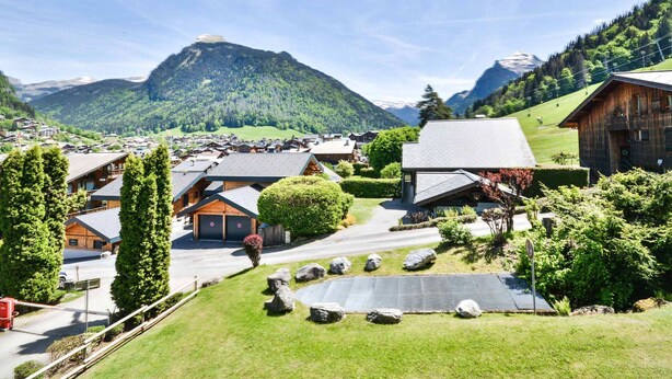 A mountain village with wooden houses, a clear sky, and a view of a mountain. - Central Morzine apartment, 6 pers, south balcony (Morzine)