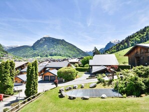 A mountain village with wooden houses, a clear sky, and a view of a mountain. - Central Morzine apartment, 6 pers, south balcony (Morzine)