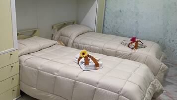 A bedroom with two beds, a wardrobe, and a marble-tiled floor.