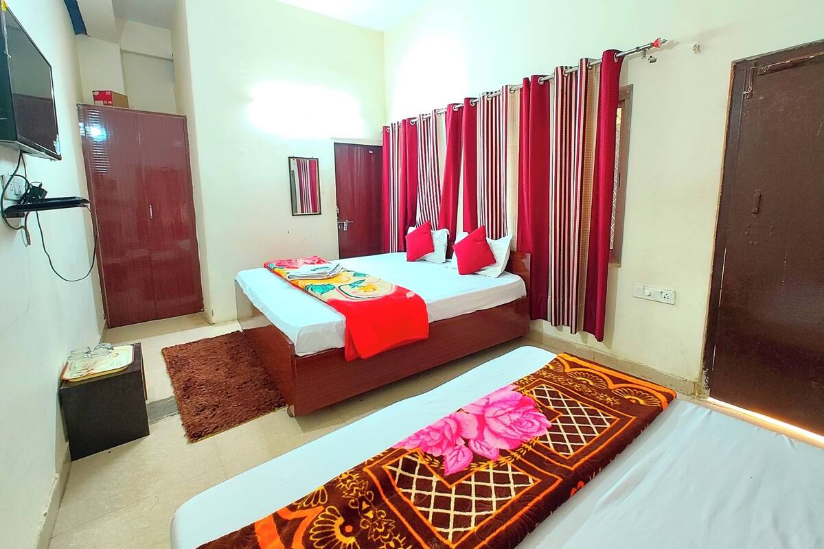 A bedroom with a bed, bedside tables, a wardrobe, a mirror, and a TV.
