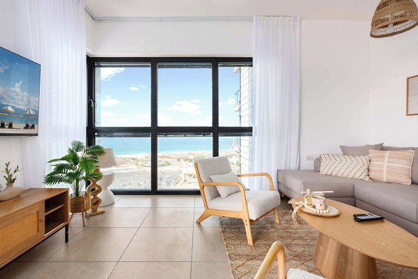 Bright living room opens to sweeping sea views, creating a relaxing atmosphere near the beach.