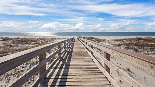A wooden boardwalk leading to the beach with a clear sky and clouds. - Gulf Shores Plantation 2123 Fun & Games (Gulf Shores)