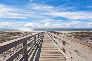 A wooden boardwalk leading to a beach with a clear sky. - Gulf Shores Plantation 2123 Fun & Games (Gulf Shores)