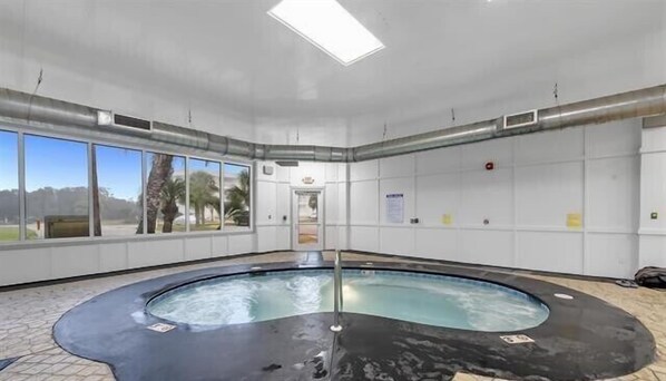 A large indoor swimming pool with a view of palm trees and a clear sky. - Gulf Shores Plantation 2123 Fun & Games (Gulf Shores)