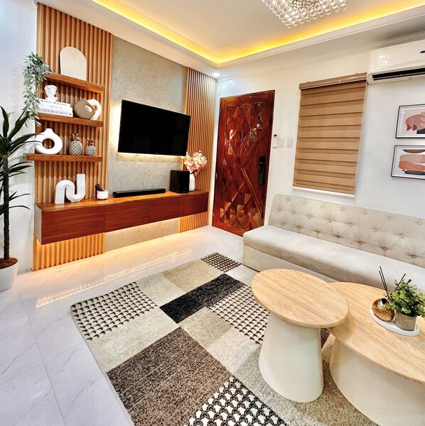 Signature Condo, 2 Bedrooms, City View | Living room | 50-inch Smart TV with digital channels, Netflix, streaming services - Annie's Place Puerto Princesa (Puerto Princesa)
