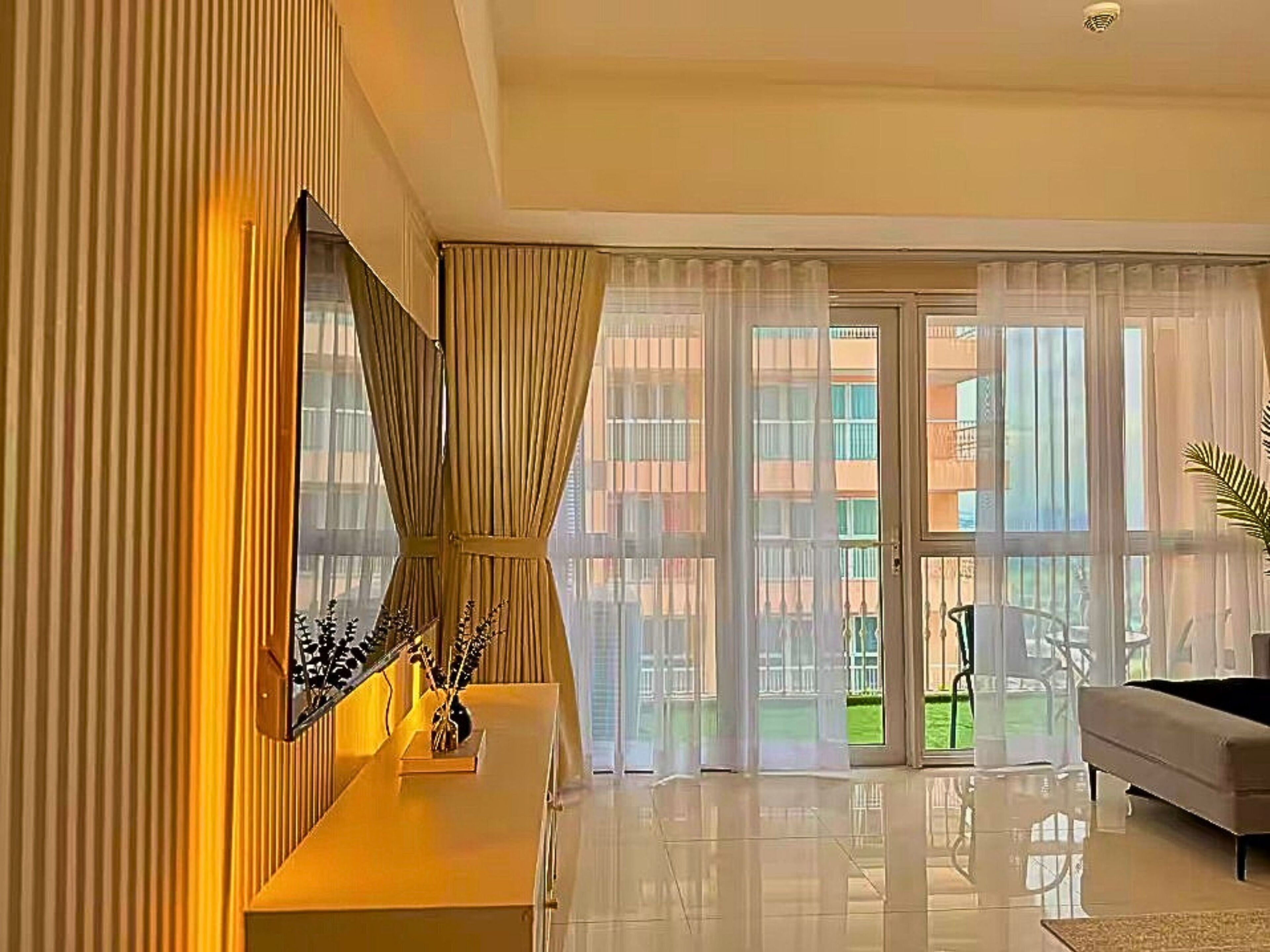 Ein modernes Wohnzimmer mit großem Fenster, einer Couch und einer Wanddekoration.