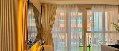 Ein modernes Wohnzimmer mit großem Fenster, einer Couch und einer Wanddekoration.