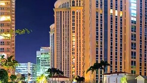 A high-rise hotel with multiple floors, large windows, and a well-lit facade.